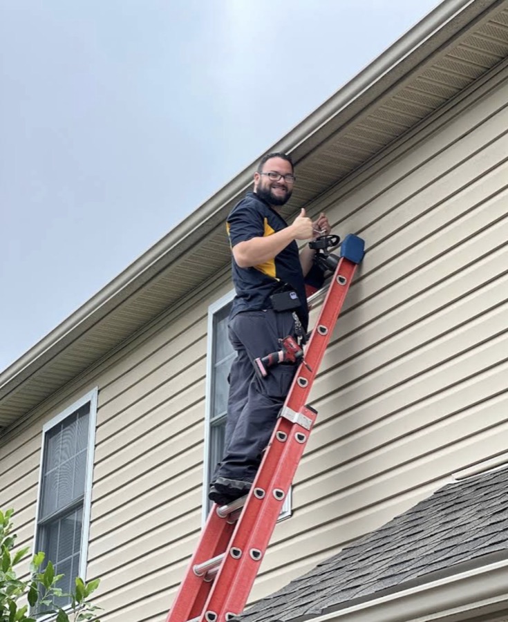 JEOAH Electric technician on a ladder at a Lehigh Valley home, giving a thumbs-up