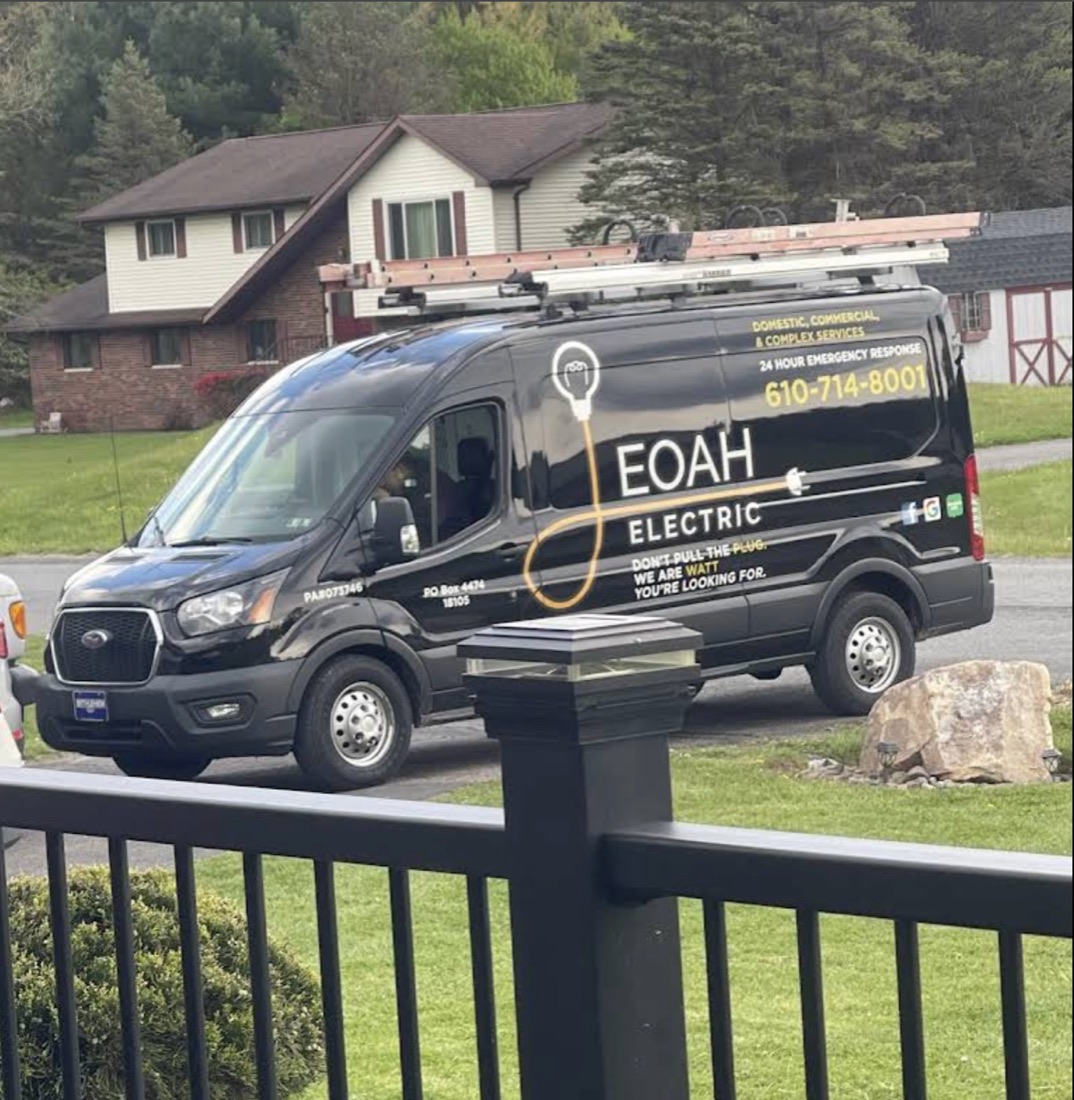A JEOAH Electric van with the family acronym lightbulb logo, parked outside a Lehigh Valley home